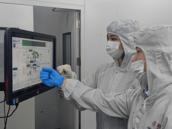 宋学颖（左）正在查看工艺和设备情况。新华社发
